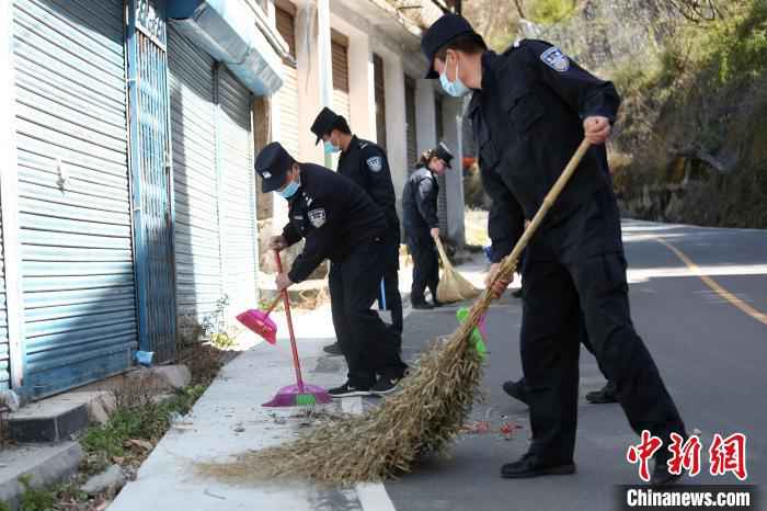 图为边检站民警清扫路边垃圾。 邹兴国 摄  中尼边境樟木口岸开展爱国卫生运动 助力疫情防控
